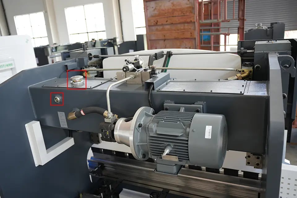 Porta de enchimento de óleo hidráulico da prensa dobradeira KRRASS (canto superior direito) e porta de inspeção (canto inferior esquerdo)