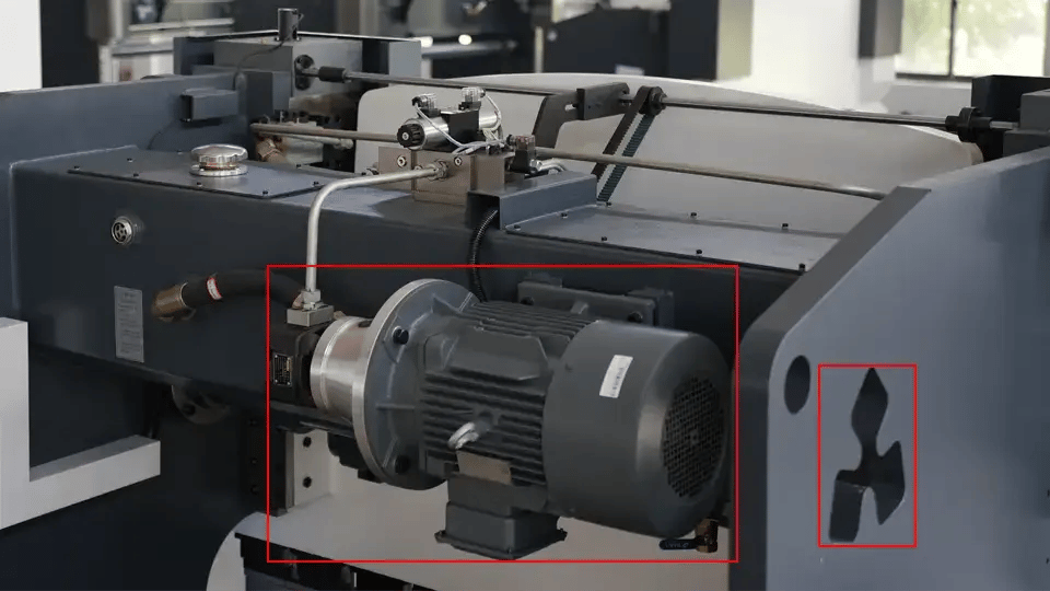 Motor principal da prensa dobradeira NC (à esquerda) e orifício de observação da lâmina de ar (à direita).